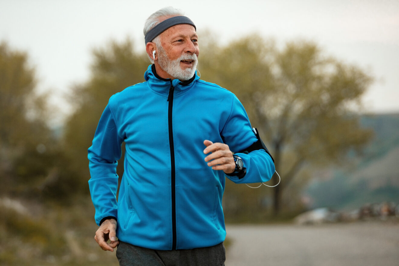 Happy senior man jogging in nature.